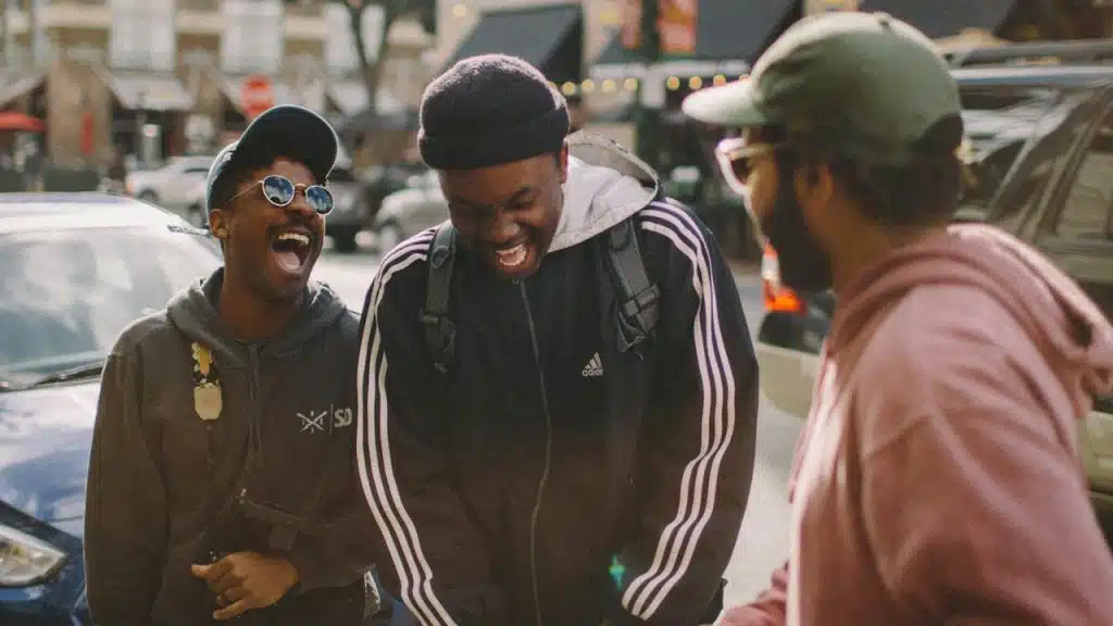 A group of men laughing and enjoying themselves while standing outdoors.