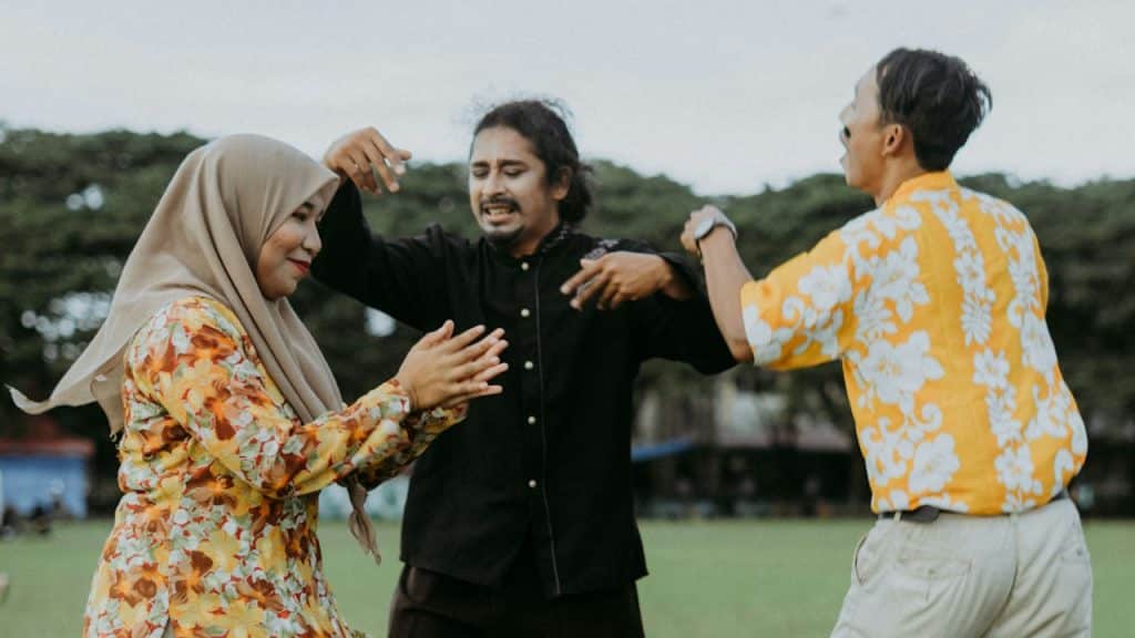 A group of people standing in a lush green field.