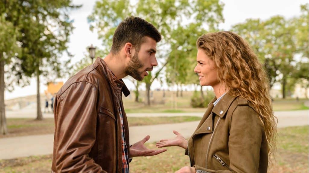A couple arguing in the middle of a park.