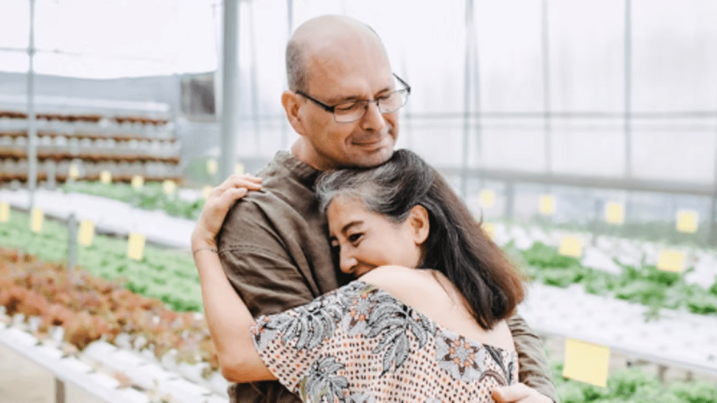 A couple hugging in a greenhouse