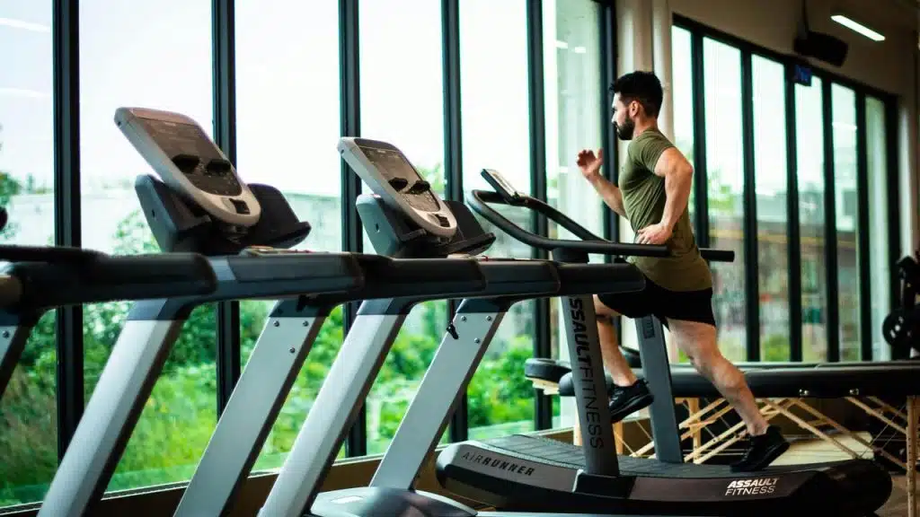 A man running on a treadmill in a gym.