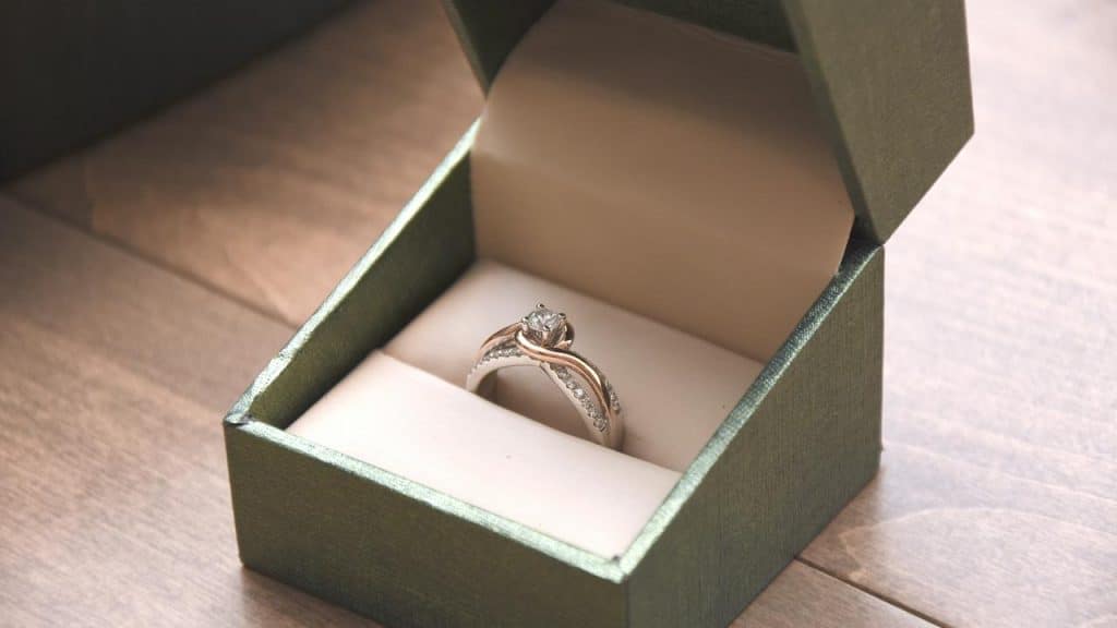 A diamond engagement ring in a green box.