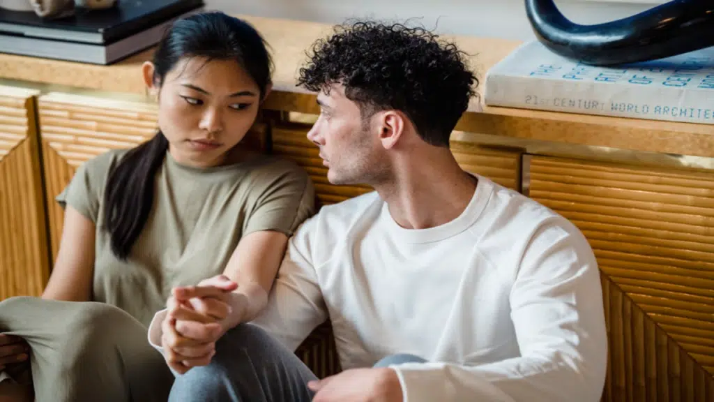 A couple having a serious talk on the floor