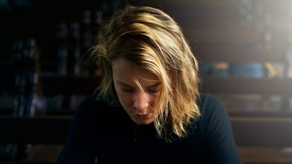 A woman staring down and looking upset.