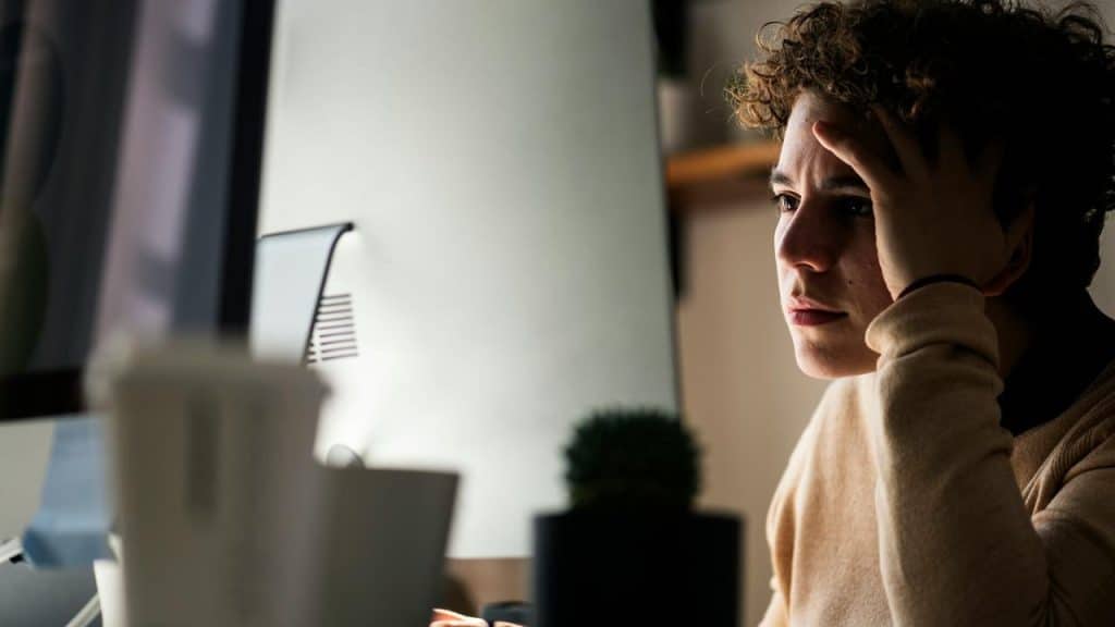 A person sitting at a desk looking stressed.