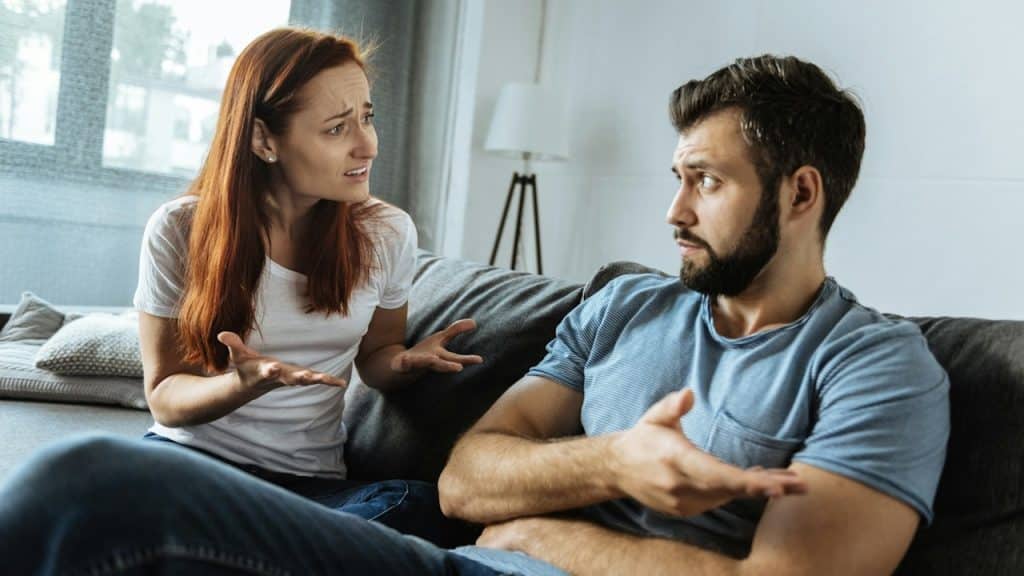 A young woman complaining to her husband, who is being indifferent to her.
