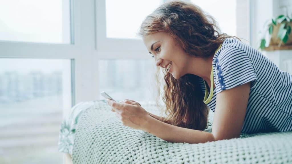 A woman smiling while texting