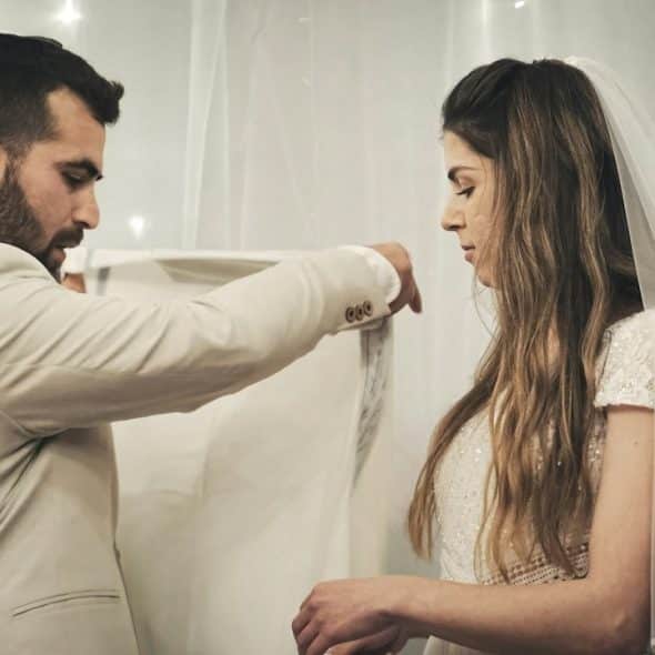 A groom and a bride are standing next to each other.