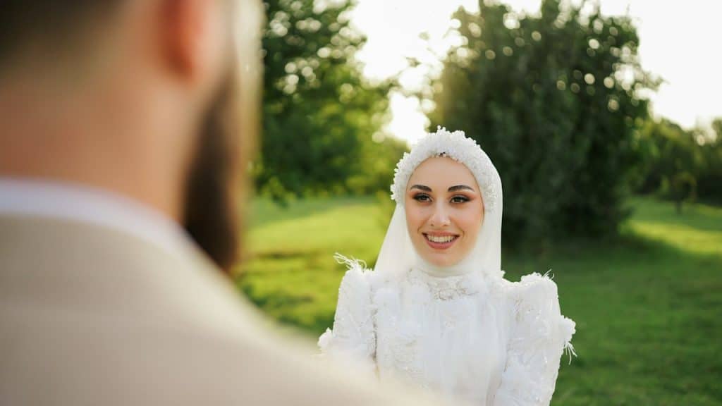 A woman in a white dress standing in front of a man.