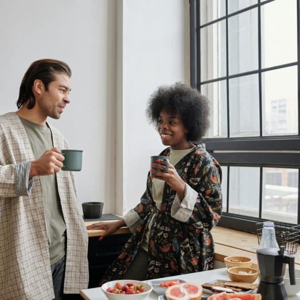 A man and woman talking while drinking coffee