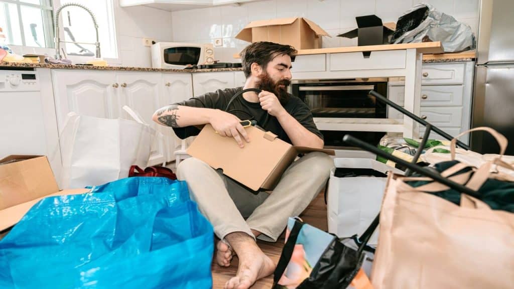 A man sitting in messy kitchen