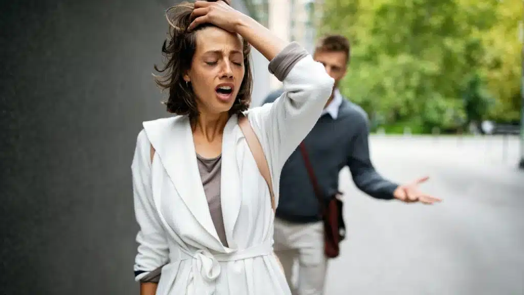 A frustrated couple arguing and having marriage problems outdoors.