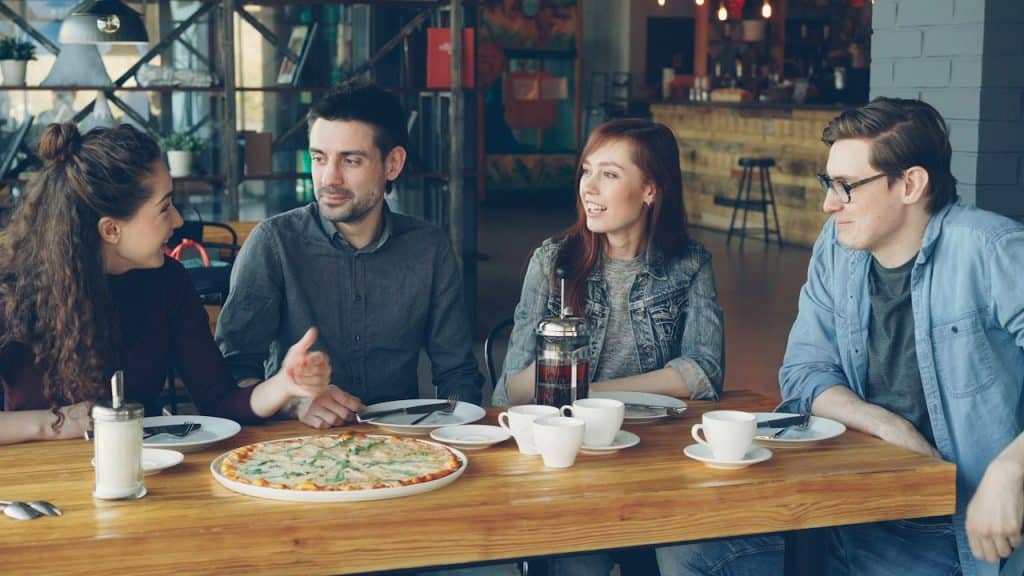 Friends enjoy-pizza-and-conversation-in-a-restaurant.