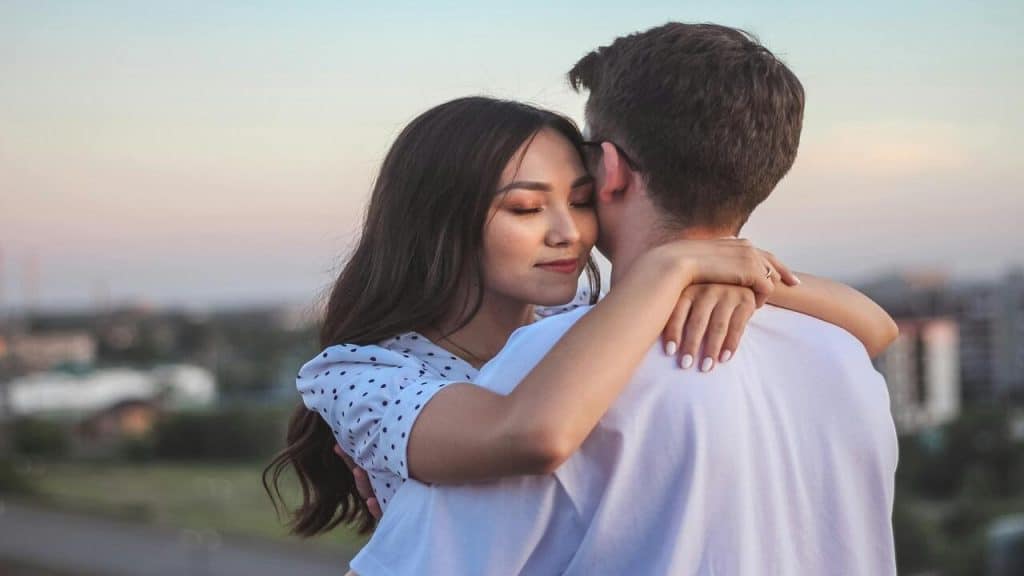 A couple hugging outdoors