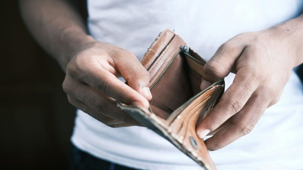 A man looking at his empty wallet