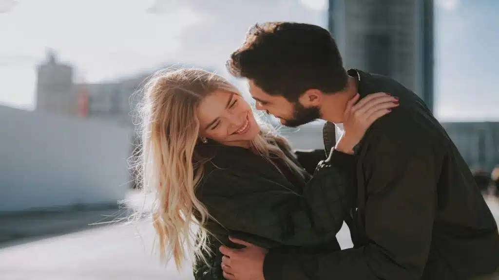 A man trying to kiss a woman outdoors 