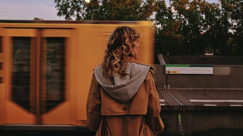 A woman watching a train passing by her.