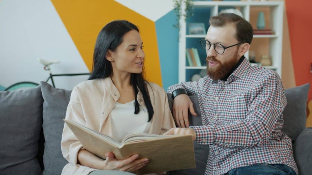 A couple looking at an open photo album together.