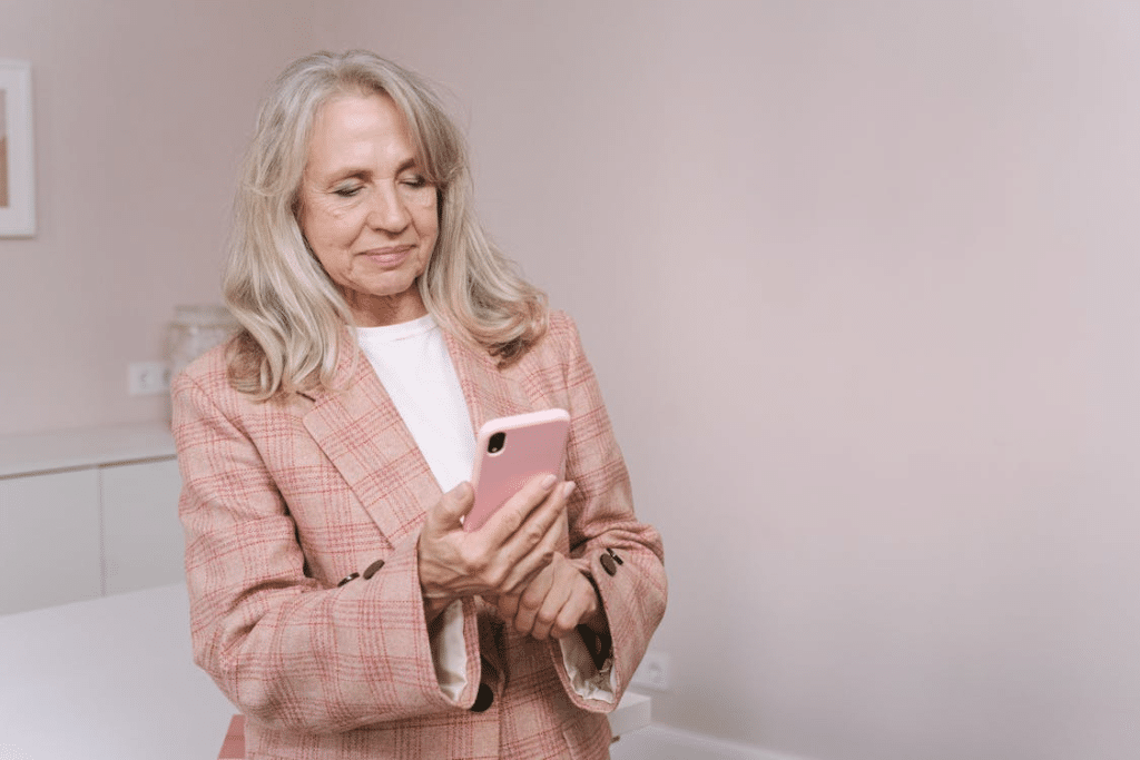A woman in pink blazer holding a phone