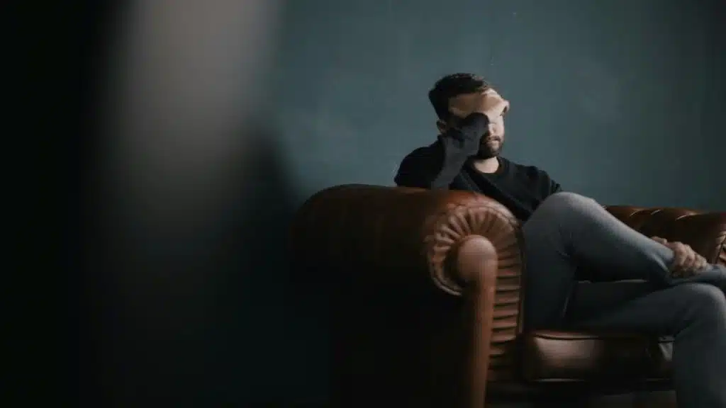 A man looking depressed on the couch
