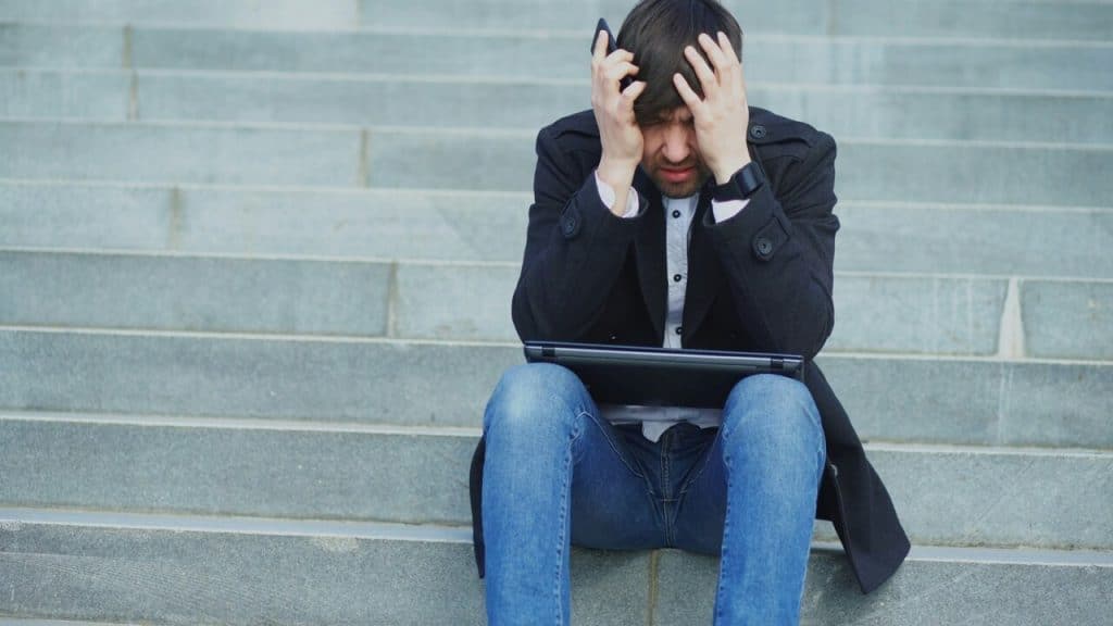 A man looking stressed with his laptop