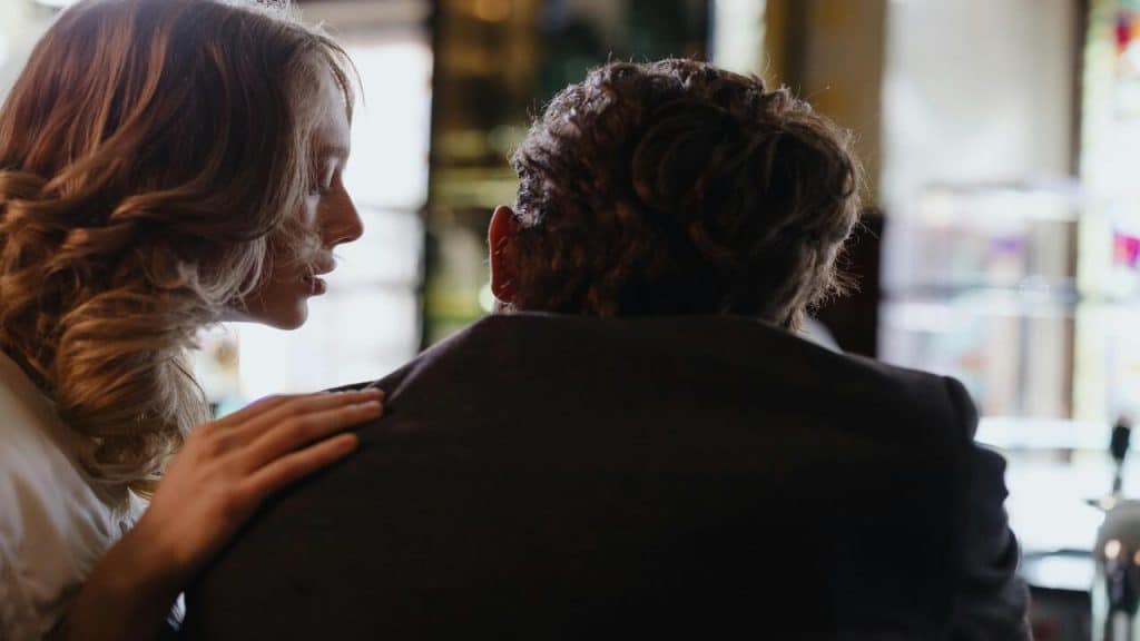 A woman touching a man’s shoulder