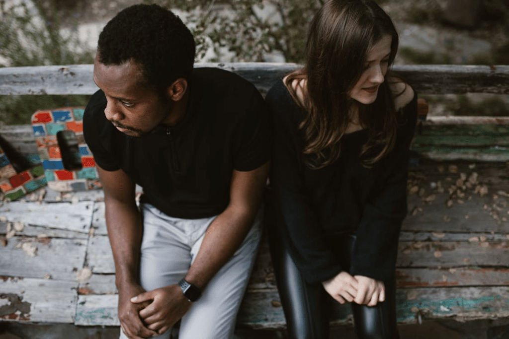Upset couple sitting on park bench