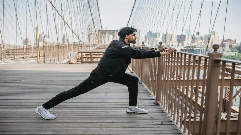 A man stretching on a bridge