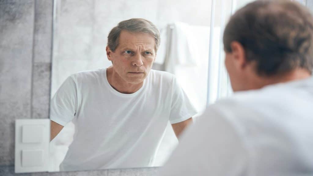 A man looking at himself in the mirror