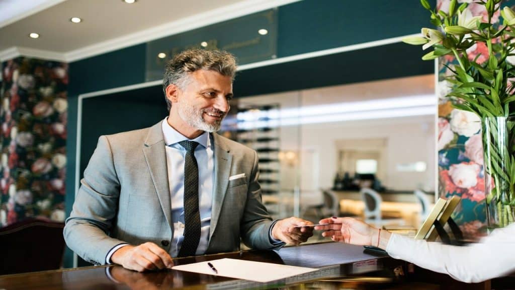 A man checking in at a hotel by himself 