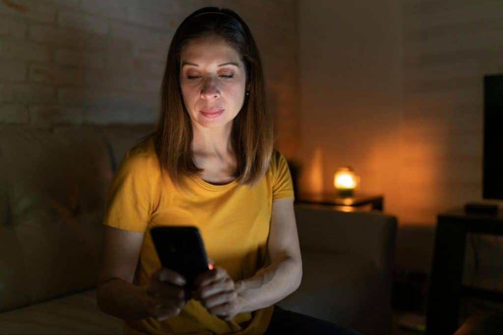 A woman using a phone and thinking