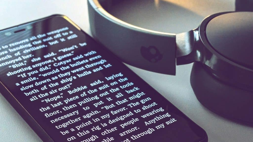 A black smartphone near Skullcandy headphones.