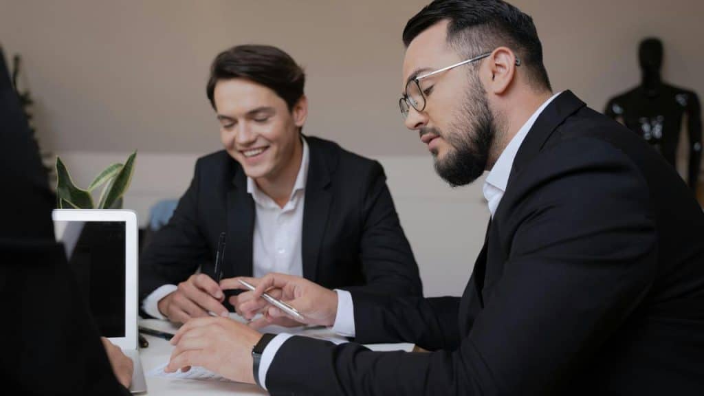 A group of business professionals reviewing documents at a desk.