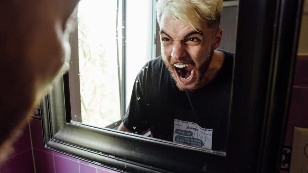 A person shouting at their reflection in a mirror.