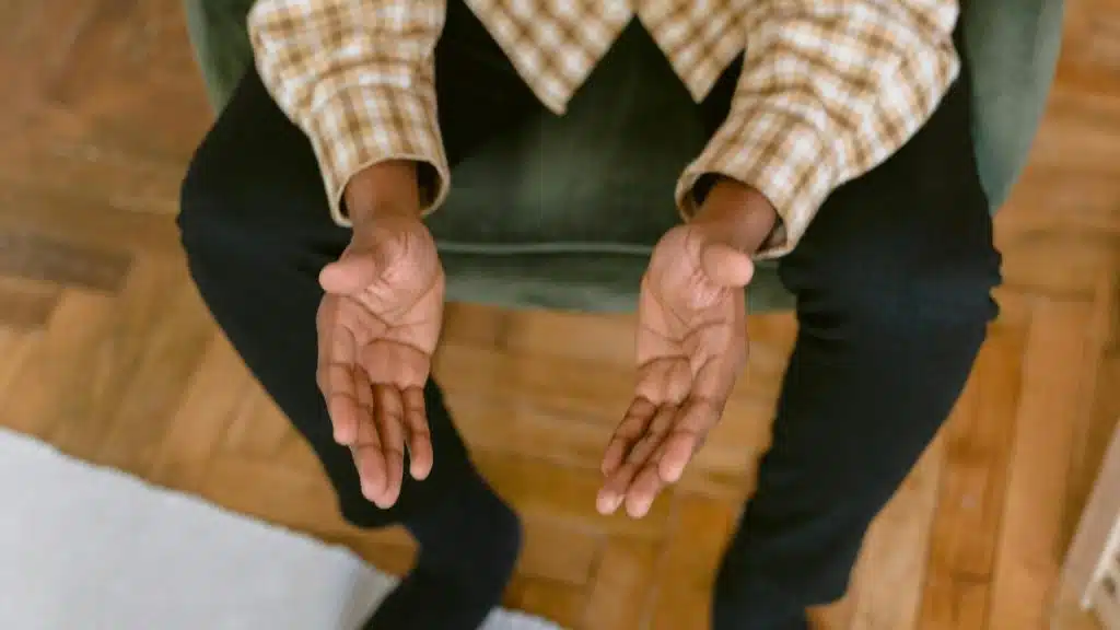 A person sitting with their hands open and palms up.