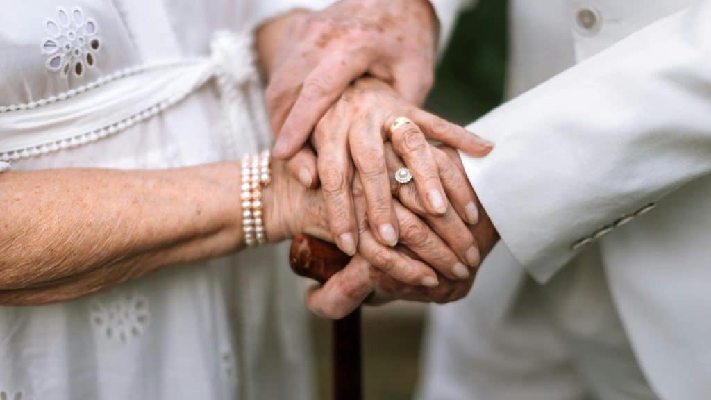 An elderly couple holding hands.