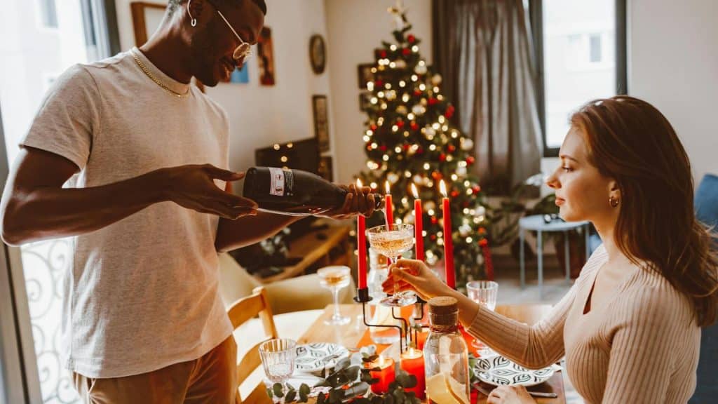 A man pouring a drink for the woman.