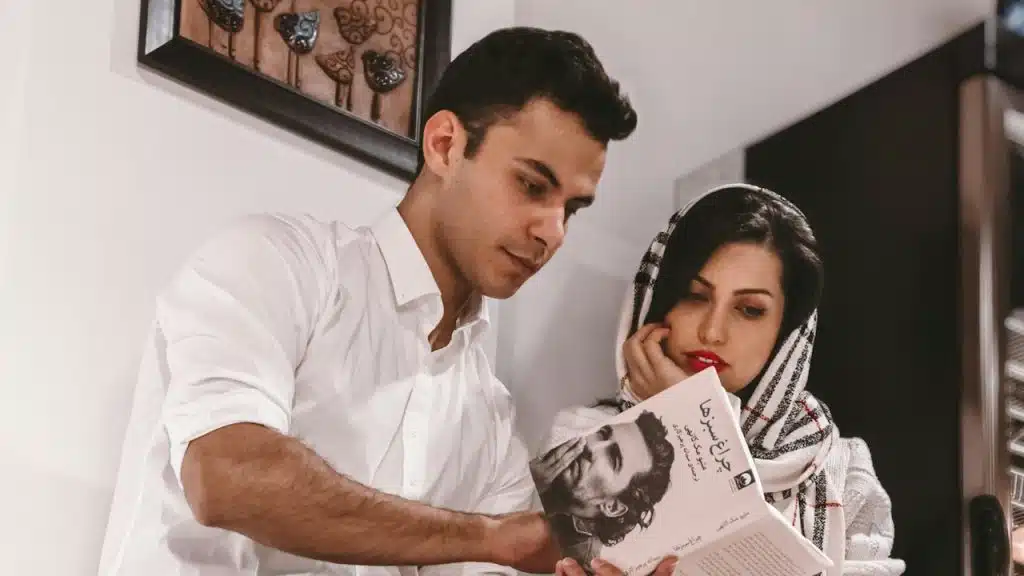 A man and woman reading from a book.