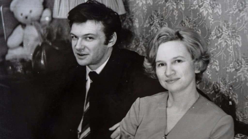 A black and white photo of a man and a woman sitting next to each other.