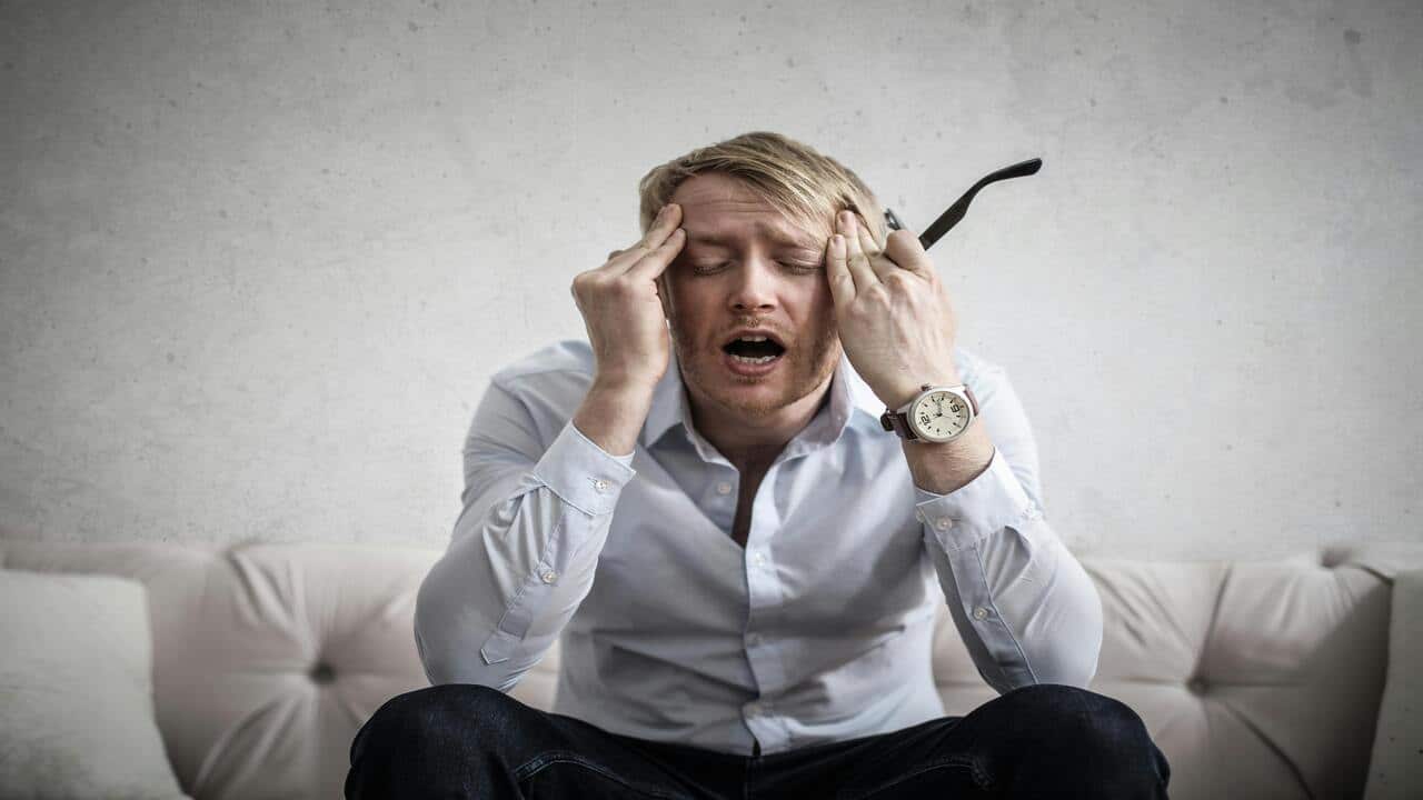 Tired man touching his head