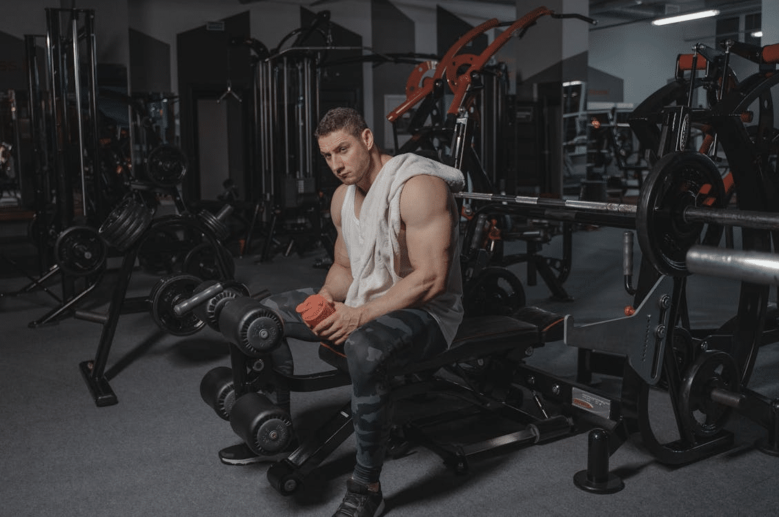 A man sitting on a gym equipment.