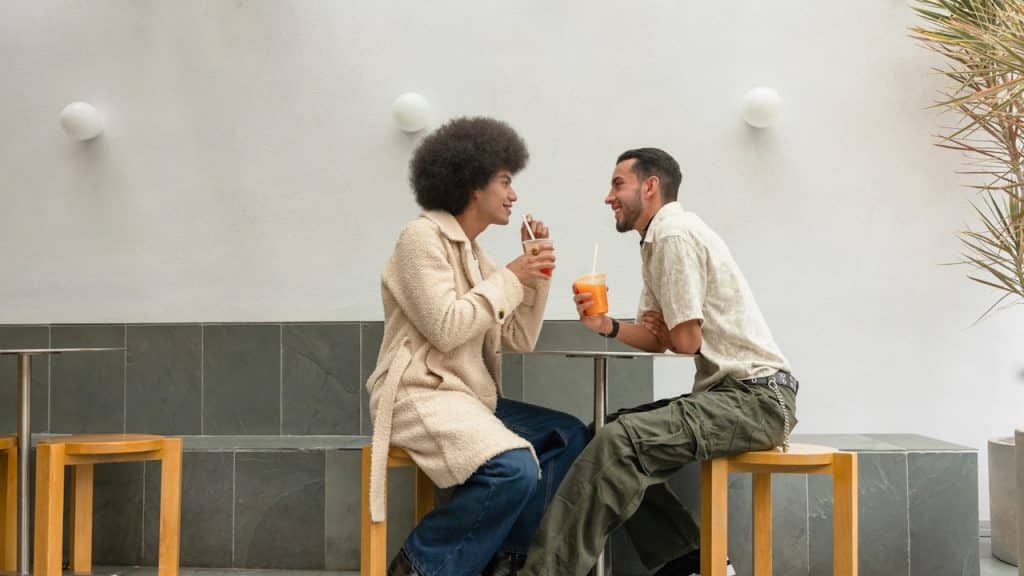 A couple talking while drinking juice in a restaurant.