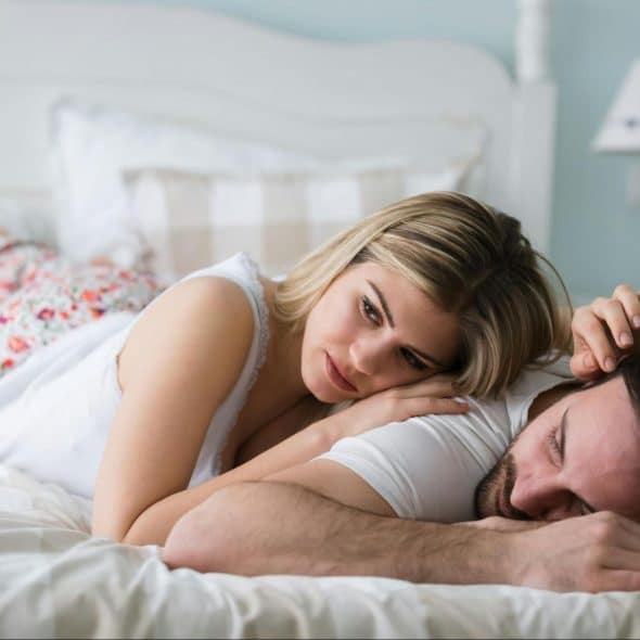 A woman waiting for a man to wake up