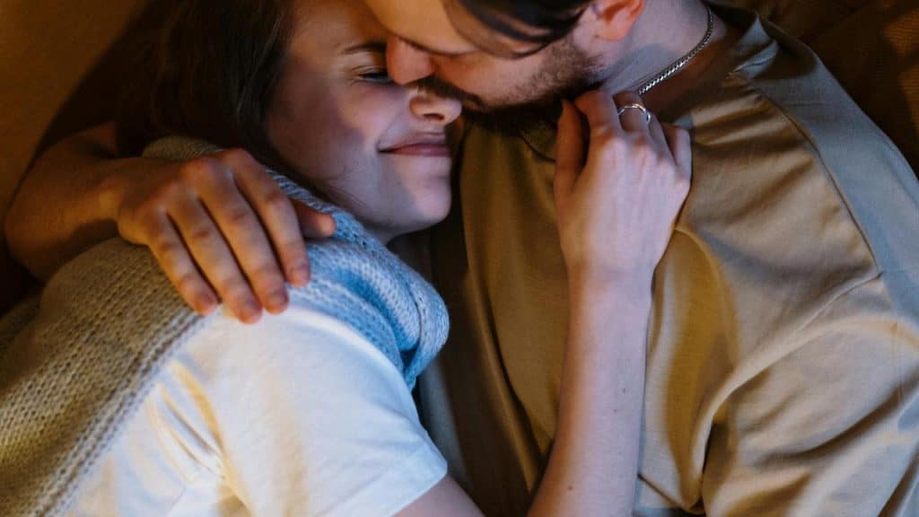 A couple cuddling closely, sharing an affectionate embrace.
