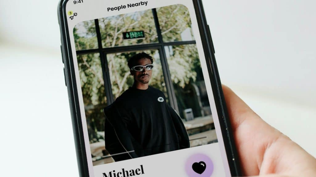 A person holding a cell phone with a picture of a man on it.