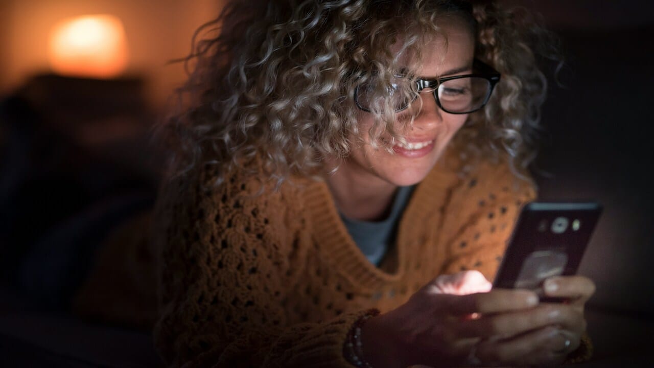 A woman texting in the dark