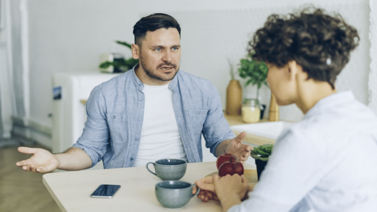 A man berating his wife while they eat