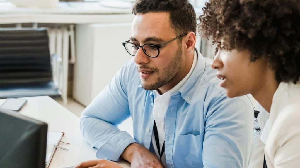 A man and a woman collaborating at a computer.