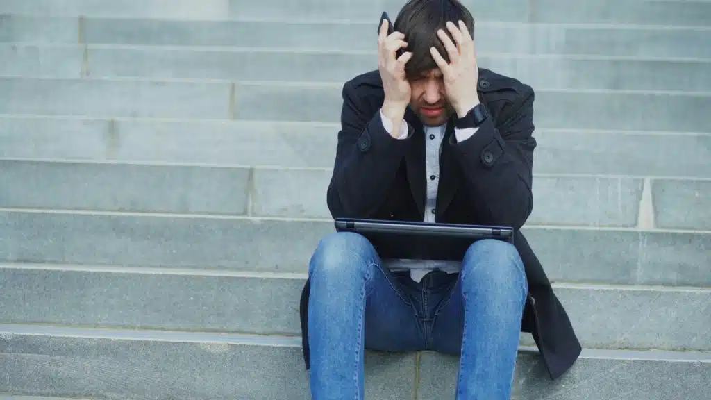 A man looking stressed with his laptop