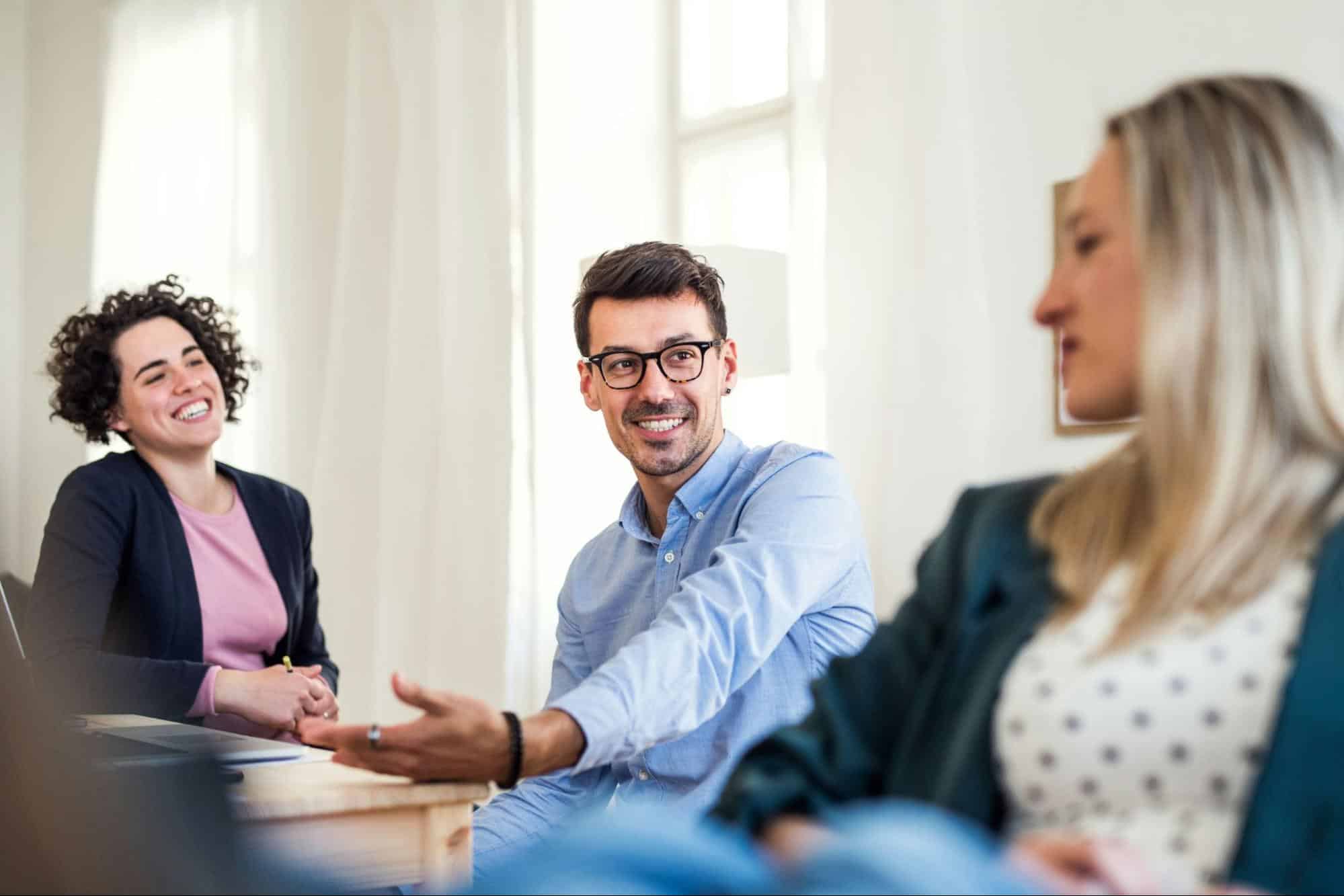 A man and two women having a conversation